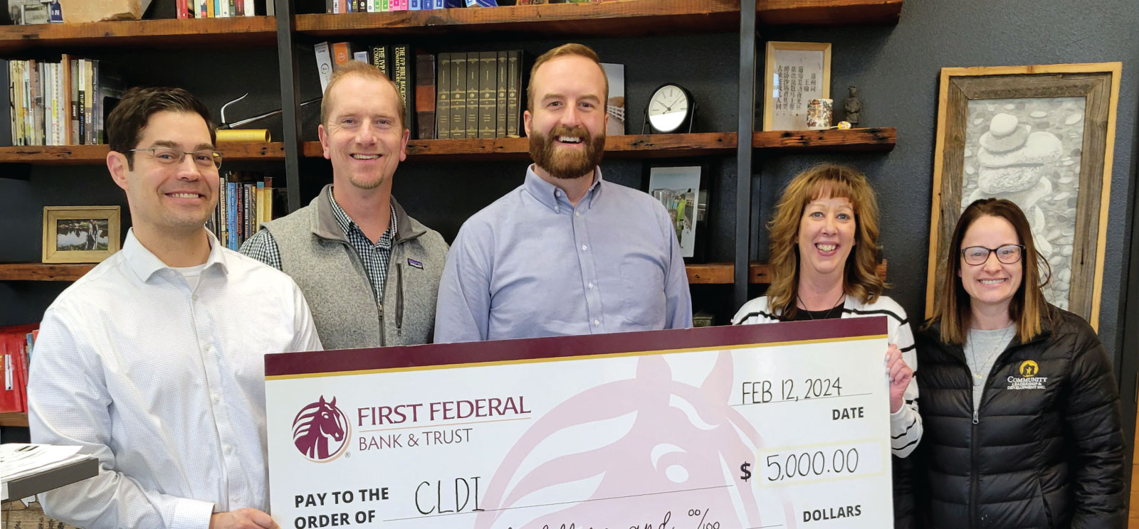 Group of people holding a donation check to CLDI